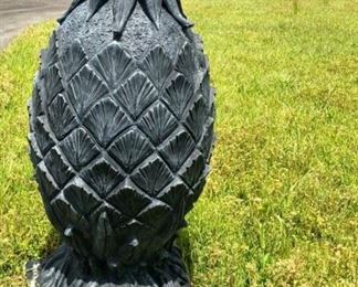 Two large concrete pineapples on each side of the drive...