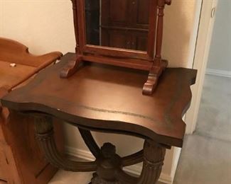 Oak framed mirror and unique table. Based on the age of other items in the home the mirror is probably and antique, at least a vintage piece.