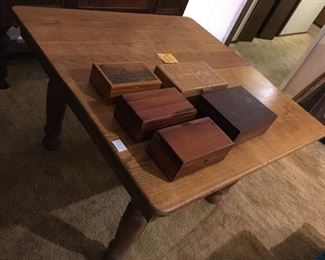 Collection of hinged, hand worked boxes on golden oak 5 legged table with leaves