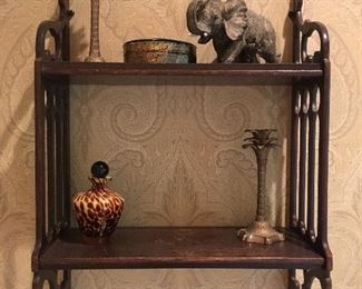 Small wall shelf; elephant figurine; palm tree candlesticks; trinket box; and glass bottle