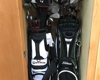 Nine, yes NINE golf bags, most containing complete sets of clubs