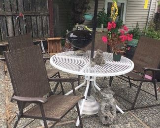 White metal patio table, 4 folding outdoor chairs, mini Weber kettle, cement yard statues