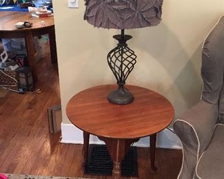 Round wood three-legged table and table lamp