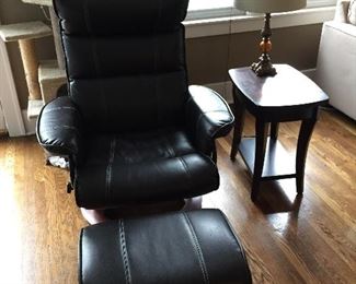 Contemporary multi-position recliner and ottoman in black leather with wood base; side table with lamp 