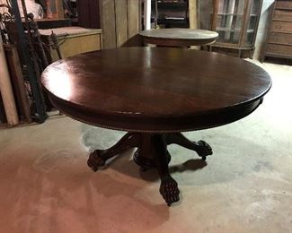 Round claw foot table with large middle pedestal has 4 additional leaves.