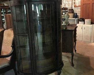 Another curved glass display cabinet with claw feet.