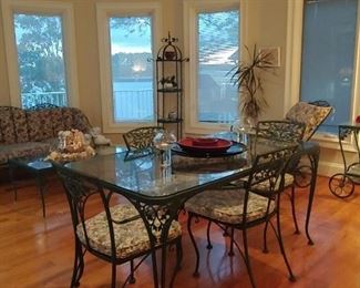 Woodard glass top table with four chairs.
