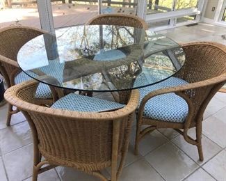 Beautiful glass top table and four comfortable wicker chairs 