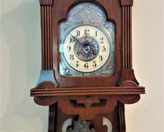 Carved Wood Wall Clock with deco style metal (pewter?) pendulum and face.