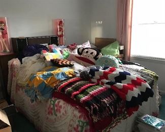 A collection of crocheted afghans (one is a stunning queen size emerald green Afghan with flowers), blankets, an Atlanta Falcons blanket (new), blankets featuring some of Concord’s landmarks, 2 sets of Sears and Roebuck canopy bed ruffled bedspreads and a couple of chenille bedspreads. Most of the afghans are new. A floral flannel sheet set with 2 pillow covers. An assortment of throw and decorative pillows. There is also a new wheelchair cushion. A vintage turntable with speakers.