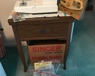 Singer sewing machine and unbranded sewing machine in cabinet. Vintage sewing notions.