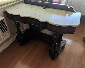 Antique desk with marble top. Has wheels can easily roll