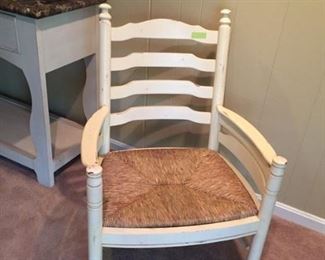 One of four white arm chairs with rush seats 