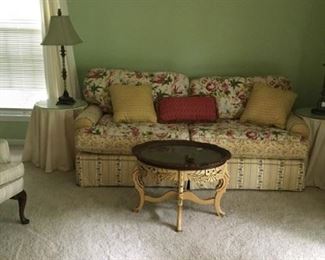 Large floral 2 seat sofa with reversible cushions with coordinating fabric. Oval carved coffee table with removable tray top