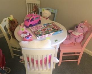 White children's table with two chairs. Three other chairs: yellow, blue and pink! Games, books and toys!