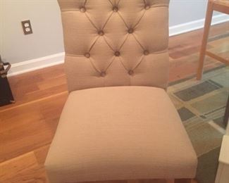One of two cream colored side chairs