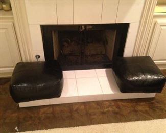 A pair of  black leather cushions for the hearth