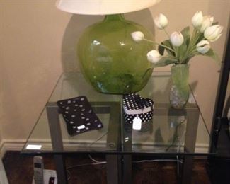 One of two glass top side tables and green lamps