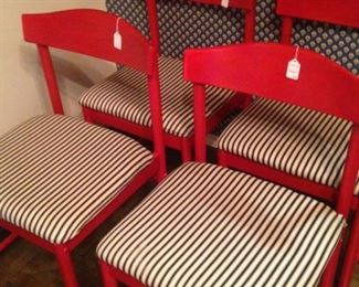 Several red chairs with upholstered seats