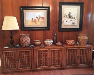 Full view of 3 mid century cabinets displaying Native American pieces with large original artwork above by very skilled painter pretending to be someone else.