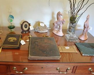 Desktop hold a copy of Dante's Paradise and Purgatory from the late 1800s and a pair of mid century pink horses.