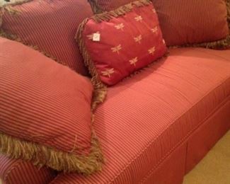 Finely upholstered red striped loveseat 