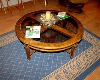 Round glass-top coffee table, area rug