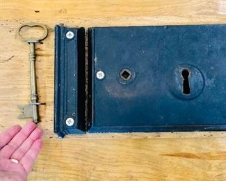 Antique oversized metal barn door lock with key that’s been mounted on wood for memento