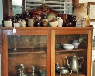 Inside the antique oak cabinet are various pewter items