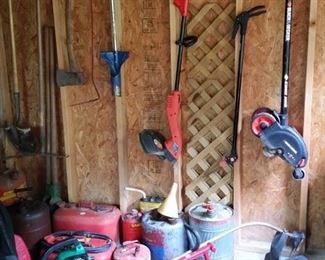 You can never have too many power tools...or gas cans.  On the wall are a Black & Decker electric edger and Black & Decker string trimmer.