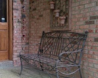 Outdoor wall decor and wrought iron bench
