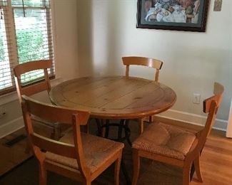 round natural wood top kitchen table with wrought iron base & raffia chairs