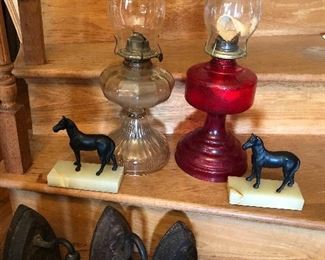 Sad irons, two cast iron horses on onyx base, two oil lamps