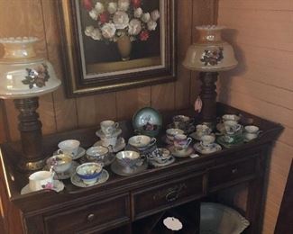 Wine cabinet.  Two hurricane lamps.  Teacup collection