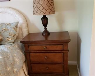 One of a pair of three drawer nightstands