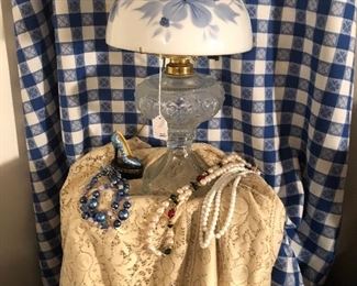 1800s electrified oil lamp base with hand painted shade.  Irish linen lace tablecloth and 1960s costume jewelry. 