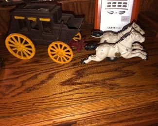 Antique cast iron stage coach with team of white horses 