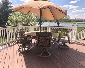 Patio table, umbrella, six swivel arm chairs, and seat cushions (not in pic).  The umbrella is blowin in the wind.