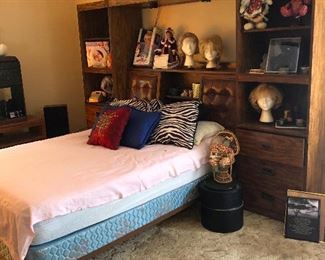 double bed with super 70s headboard that is also a console/wall unit