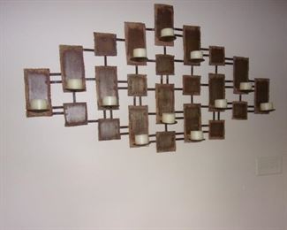 Large, cut metal wall art with candle holders.