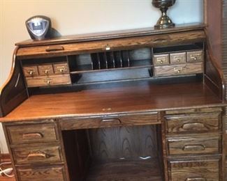Sligh rolltop desk. Oak. Model 5010-1-AC. Seven drawers in lower section including two file drawers on ball bearing slides. Pull-out writing slide in front of each pedestal. Locking tambour roll-top. Made in Holland MI.