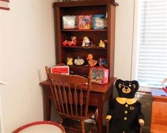 Wooden desk/cupboard with shelves holding collectible lunchboxes from the '60's-70's, and vintage pull toys