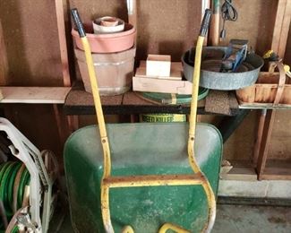 Wheelbarrel, planters, hose on rack