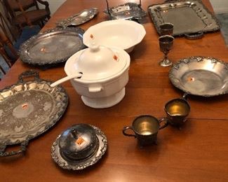 Another view of silverplate serving pieces on oval dining table