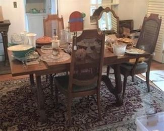 The dining room table and chairs, along with multiple kitchen serving items.