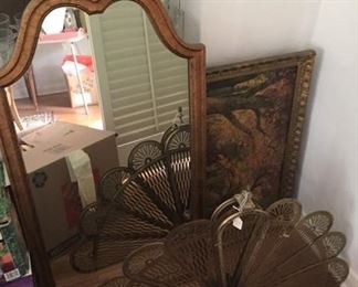 A wall mirror, painting, and peacock shaped decorative piece.