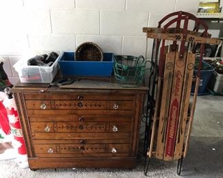 Eastlake-style chest of drawers; two vintage sleds.