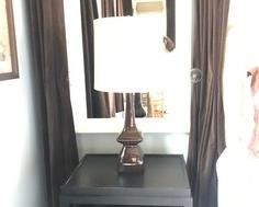 SIMPLE BLACK SIDE TABLE WITH MAGAZINE SHELVES UNDER NEATH.