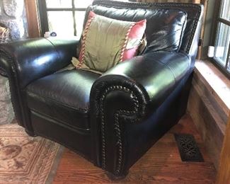 Matching black leather arm chair with rolled arms, and brads.  