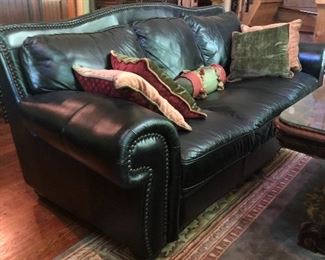 Exceptional black leather sofa with rolled arms, camel back, and brads.  